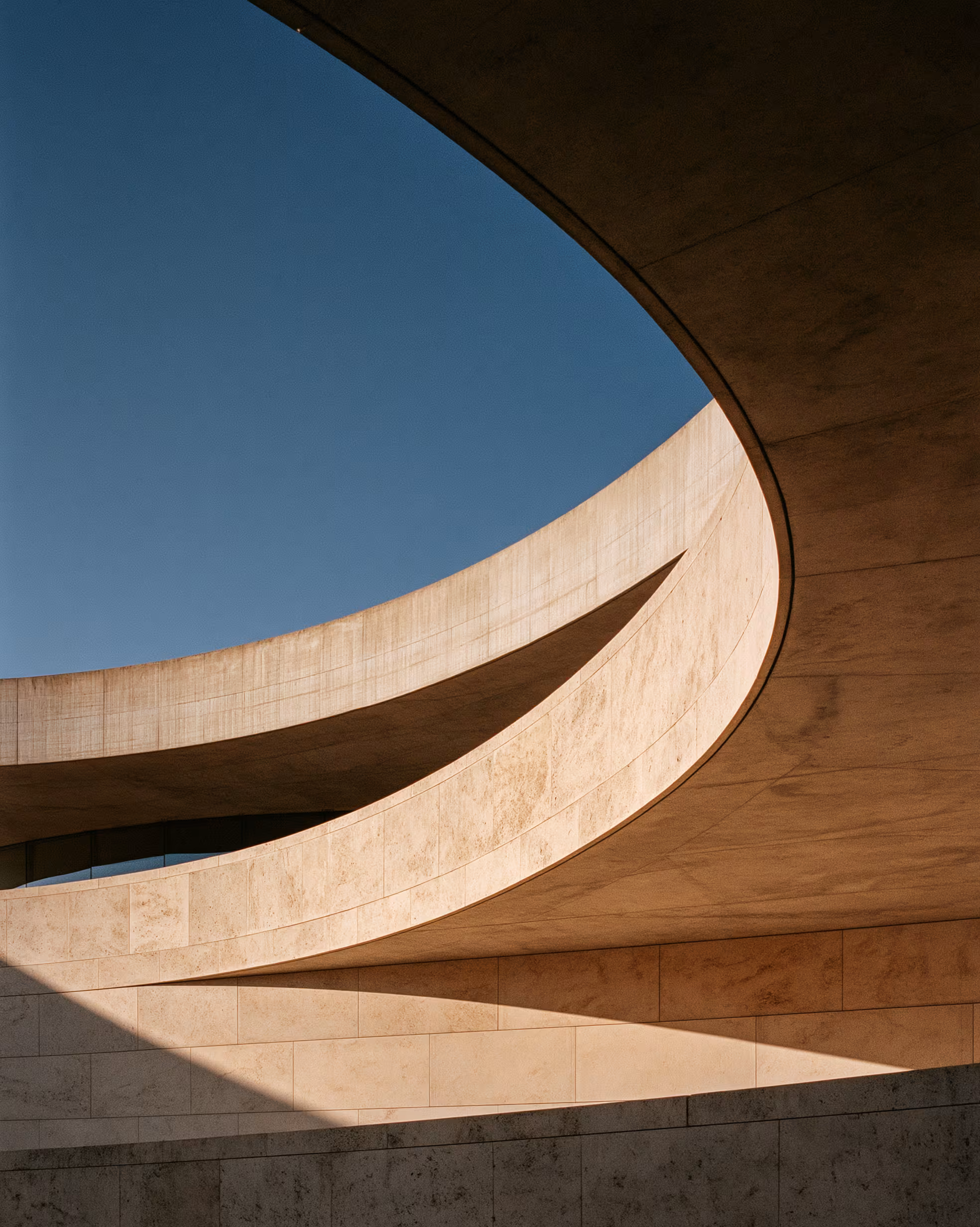 Curving modern architecture against a clear blue sky